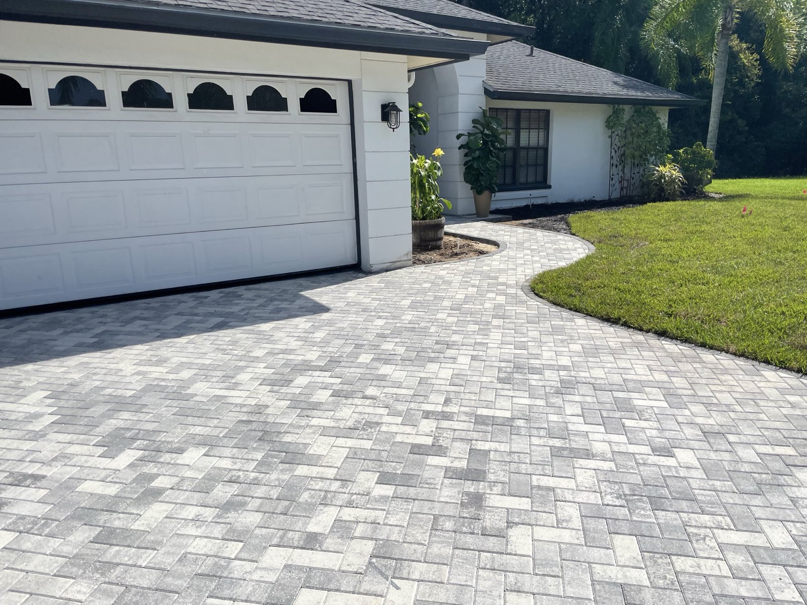Finished home exterior with a curved paver driveway