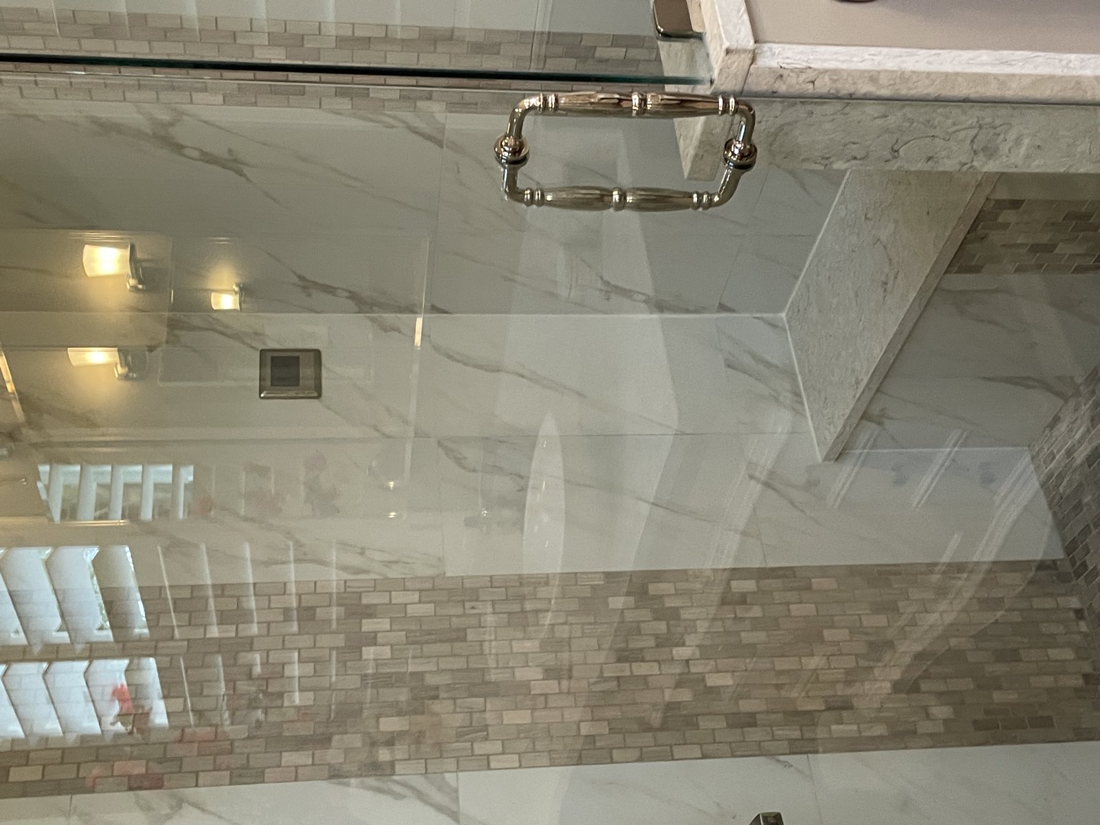 Marble walk-in shower with frameless glass